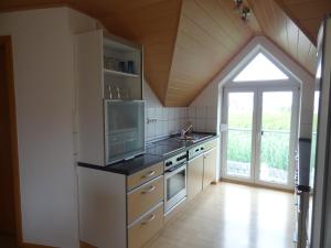 a kitchen with a stove and a sink and a window at Ferienwohnung Ebersbach in Günzburg