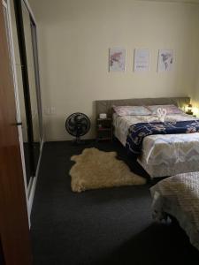 a bedroom with two beds and a rug at Apzinho do Centro in Nova Petrópolis
