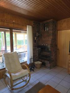 Avendorf auf FehmarnにあるRustikales Schwedenhausの暖炉付きのリビングルームにあるロッキングチェア