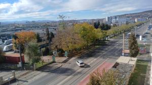 a white car is driving down a city street at Cozy Studio East-Side in Cluj-Napoca