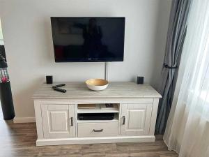 a white cabinet with a television on top of it at Fiete in Marienleuchte +14 photos