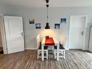 a dining room with a white table and chairs at Fiete in Marienleuchte