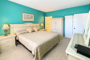 a bedroom with a bed and a blue wall at Welcome to Oasis #21 Your Coastal Retreat in Daytona Beach Shores-Walk To The Beach in Daytona Beach Shores +18 photos