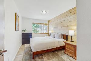 een slaapkamer met een bed en een houten wand bij Alpine Retreat in Truckee +20 foto's