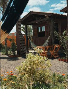 a hammock in front of a cabin at Pousada Toca da Coruja Chales pequeno in Balneário Gaivotas