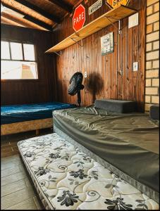 a bedroom with a bed in a wooden cabin at Pousada Toca da Coruja Chales pequeno in Balneário Gaivotas