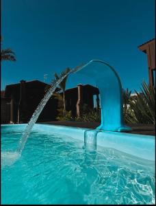 a water fountain in a swimming pool at Pousada Toca da Coruja Chales pequeno in Balneário Gaivotas