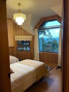 a bedroom with a bed and a large window at Beautiful Plot Lake and Volcano View in Puerto Varas