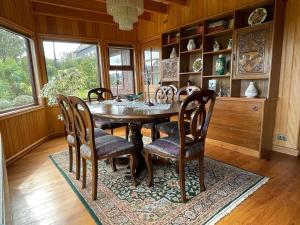 a dining room with a wooden table and chairs at Beautiful Plot Lake and Volcano View in Puerto Varas +40 photos