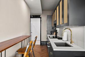 a kitchen with a sink and a counter with chairs at Freeman 903 by Rove 1BR Condo with Shared Amenities in New York