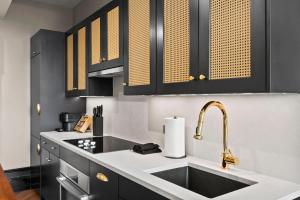 a kitchen with a sink and black cabinets at Freeman 903 by Rove 1BR Condo with Shared Amenities in New York