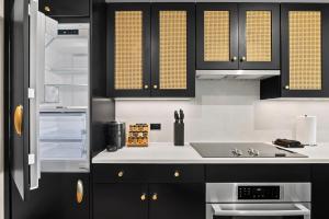 a kitchen with black cabinets and a sink at Freeman 903 by Rove 1BR Condo with Shared Amenities in New York +23 photos
