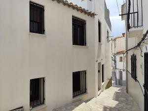 an alley with black windows in a white building at Raíces de Alcalá in Alcalá del Júcar