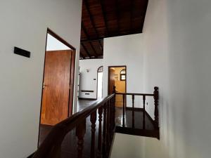 a hallway with a stairway with a wooden door at The Shan Guest House in Nugegoda
