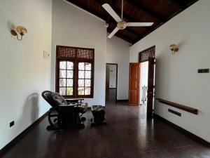 a living room with a chair and a ceiling fan at The Shan Guest House in Nugegoda