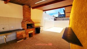 a living room with a brick fireplace in a house at Casa em Ubatuba a 350m da Praia das Toninhas - Casa Praia in Ubatuba