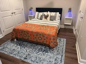 een slaapkamer met een bed met een oranje deken en een tapijt bij War Eagle Landing a 4BR and 3BA Family-Friendly Auburn Retreat in Auburn