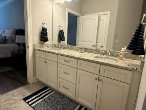een badkamer met twee wastafels en een grote spiegel bij War Eagle Landing a 4BR and 3BA Family-Friendly Auburn Retreat in Auburn +11 foto's