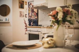 a kitchen with a table with a vase of flowers at Casamè Apartment Sulmona - a due passi da centro, free bike park in Sulmona