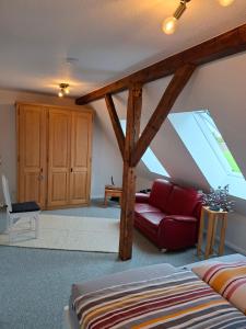 a living room with a red couch and a window at Hof Nordholz in Großenkneten +6 photos