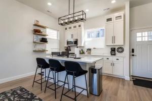 Wolf Lodge CondominiumにあるLuxury Powder Mountain Village Sanctuaryの白いキャビネットとバースツール付きの島のあるキッチンが備わります。