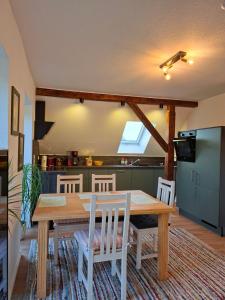 a kitchen and dining room with a wooden table and chairs at Hof Nordholz in Großenkneten