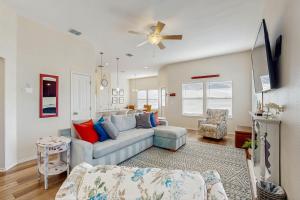 ロックポートにあるSunrise Retreatのソファと天井ファンのあるリビングルーム