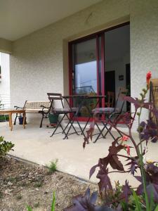 a patio with two chairs and a table and a bench at Gîte en Chartreuse - Le nid du Grand-Duc in Saint-Aupré