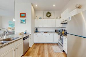ロックポートにあるSunrise Retreatの白いキャビネットと木製の床を備えたキッチン