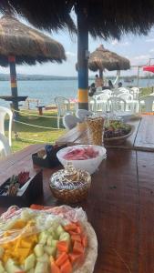 a wooden table topped with bowls of food on a beach at Pontal da lagoa in Planaltina