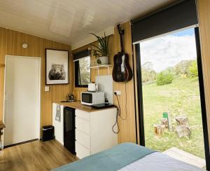 une cuisine avec un four micro-ondes sur un comptoir et une fenêtre dans l'établissement Kanimbla Sunsets by Tiny Away, à Kanimbla 23 autres photos