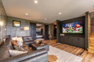 a living room with a leather couch and a flat screen tv at Bucks and Bunnies at Eagles Nest in Elk Park