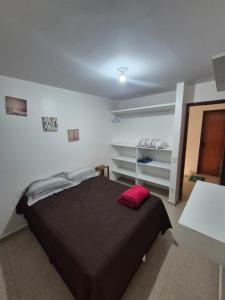 a bedroom with a bed with a red pillow on it at Bangalô duplex 602 - Riviera do Atlântico in Conde +61 photos