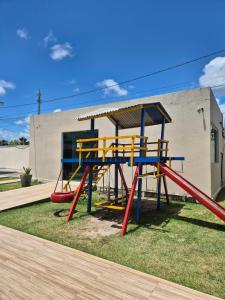 a playground with a slide on the grass at Bangalô duplex 602 - Riviera do Atlântico in Conde +72 photos