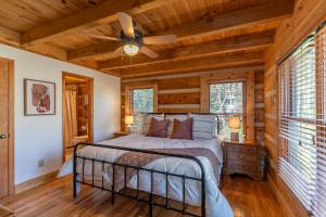 LaxonHappy Trees Cabin的带床和吊扇的卧室