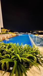 ein großer blauer Swimmingpool auf einem Gebäude in der Unterkunft Minimalist stay Midas Seri Alam High floor in Masai