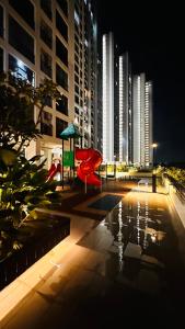 ein Spielplatz in einer Stadt in der Nacht mit hohen Gebäuden in der Unterkunft Minimalist stay Midas Seri Alam High floor in Masai