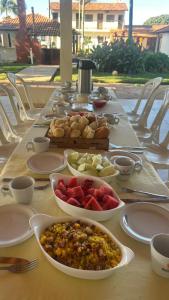 a long table with bowls of food on it at Pontal da lagoa in Planaltina