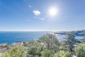 a view of the ocean from a hill with trees at Petit Paradis vue Mer- Plage et calanques a 3 mn in Saint-Raphaël