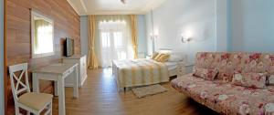 a room with a couch and a bed and a television at Marseille Resort in Zatoka