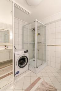 a washing machine in a bathroom with a shower at Beautiful 2-bedroom apartment in Bergen