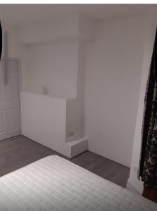 Una habitación blanca con una cama y una pared blanca. en The Wellington Hotel & Holiday Flats, en Morecambe 2 fotos más