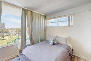 a bedroom with a bed and a large window at Skyline & Sand in Daytona Beach +14 photos