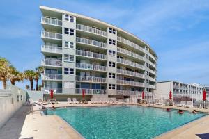 a swimming pool in front of a large building at Skyline & Sand in Daytona Beach