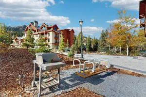 een grill en stoelen voor een gebouw bij Eagle Springs East 402: Buffaloberry Suite in Solitude