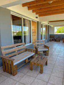 a porch with wooden benches and tables and windows at Edificio Mitre in Maipú