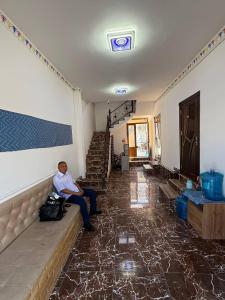 ブハラにあるAfsonaの部屋のソファに座る男