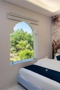 KhātuにあるKnight Oasisの窓とベッド付きのベッドルーム1室