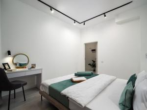 a bedroom with a bed and a desk and a mirror at Seven Premium Apartments by Mega Mall in Almaty