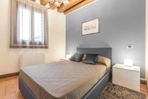 um quarto com uma cama grande e uma janela em Ca' del Monastero 6 Collection Chic Apartment for 4 Guests with Lift em Veneza